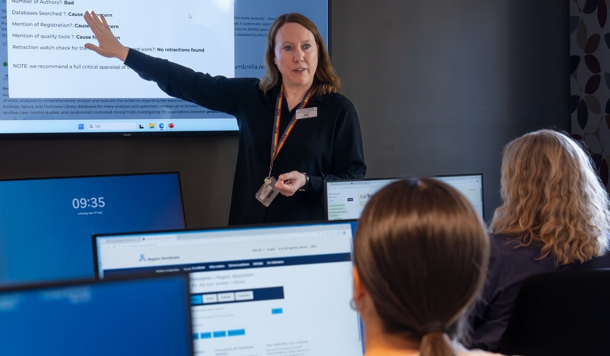 En kvinna som håller en presentation för en grupp människor.